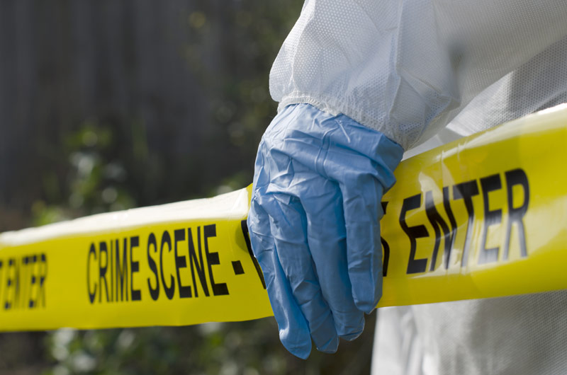 Crime scene tape with gloved hand