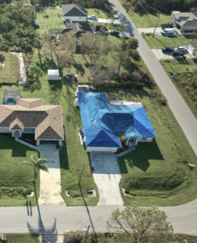 aerial-view-damaged-hurricane-ian-house-roof-covered-with-blue-protective-tarp-against-rain-water-leaking-until-replacement-asphalt-shingles